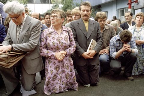 Betend zeigen Streikende 1980 vor der Lenin-Werft in Danzig ihren Protest. Vorn kniet die Kranführerin Anna Walentynowicz, deren Entlassung wegen ihres Einsatzes für die Rechte der Belegschaft einer der Auslöser für den Ausstand war. Rechts neben ihr Lech Wałęsa, einstiger Werft-Elektriker und nun Anführer des Streikkomitees