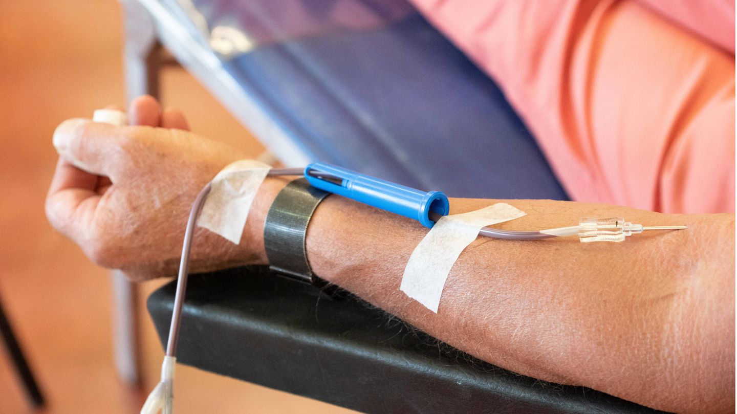 Ein Blutspender sitzt auf dem Liegestuhl und spendet Blut