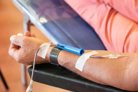 Ein Blutspender sitzt auf dem Liegestuhl und spendet Blut