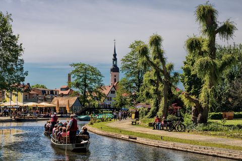 Zwei Boote mit einigen Leuten drauf wird von einem Gondolier angeschoben