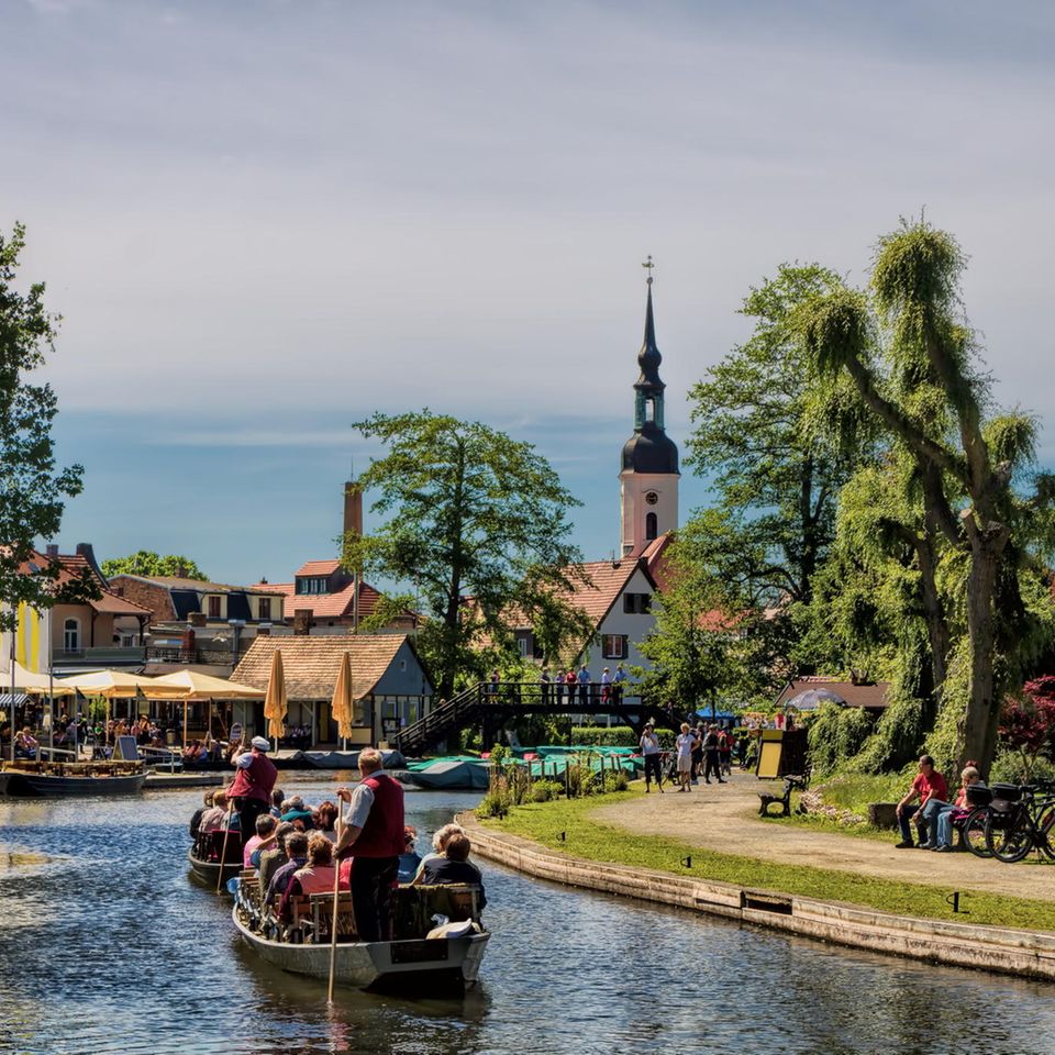 Zwei Boote mit einigen Leuten drauf wird von einem Gondolier angeschoben