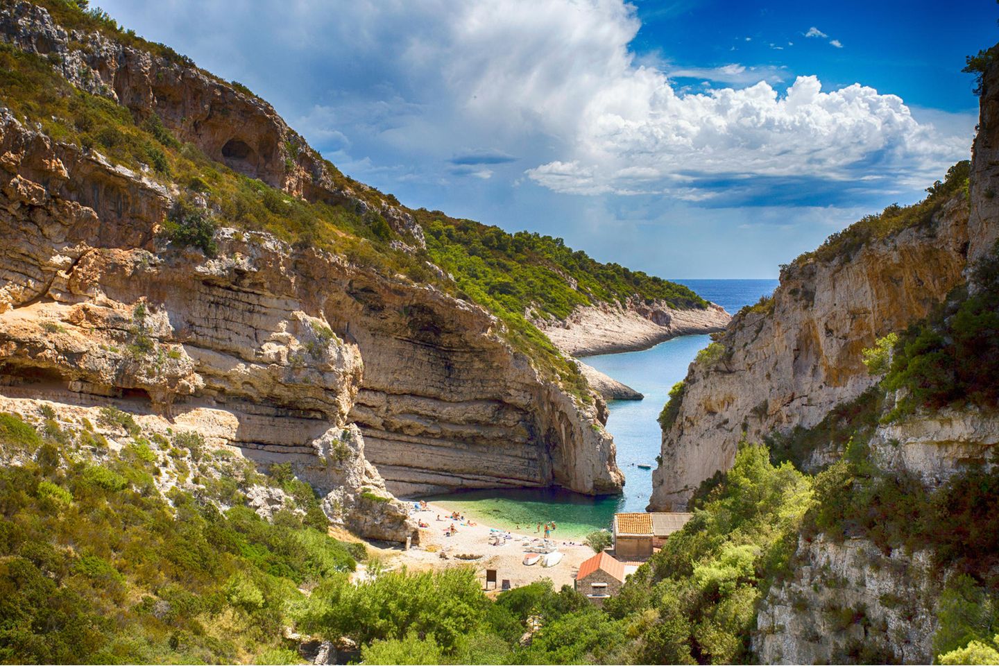Vis – Sein blaues Wunder erleben Blick von oben auf eine kleine Bucht mit klarem Wasser bei Sonnenschein