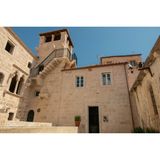 Helles Haus mit einem kleinen Turm bei strahlendem Sonnenschein