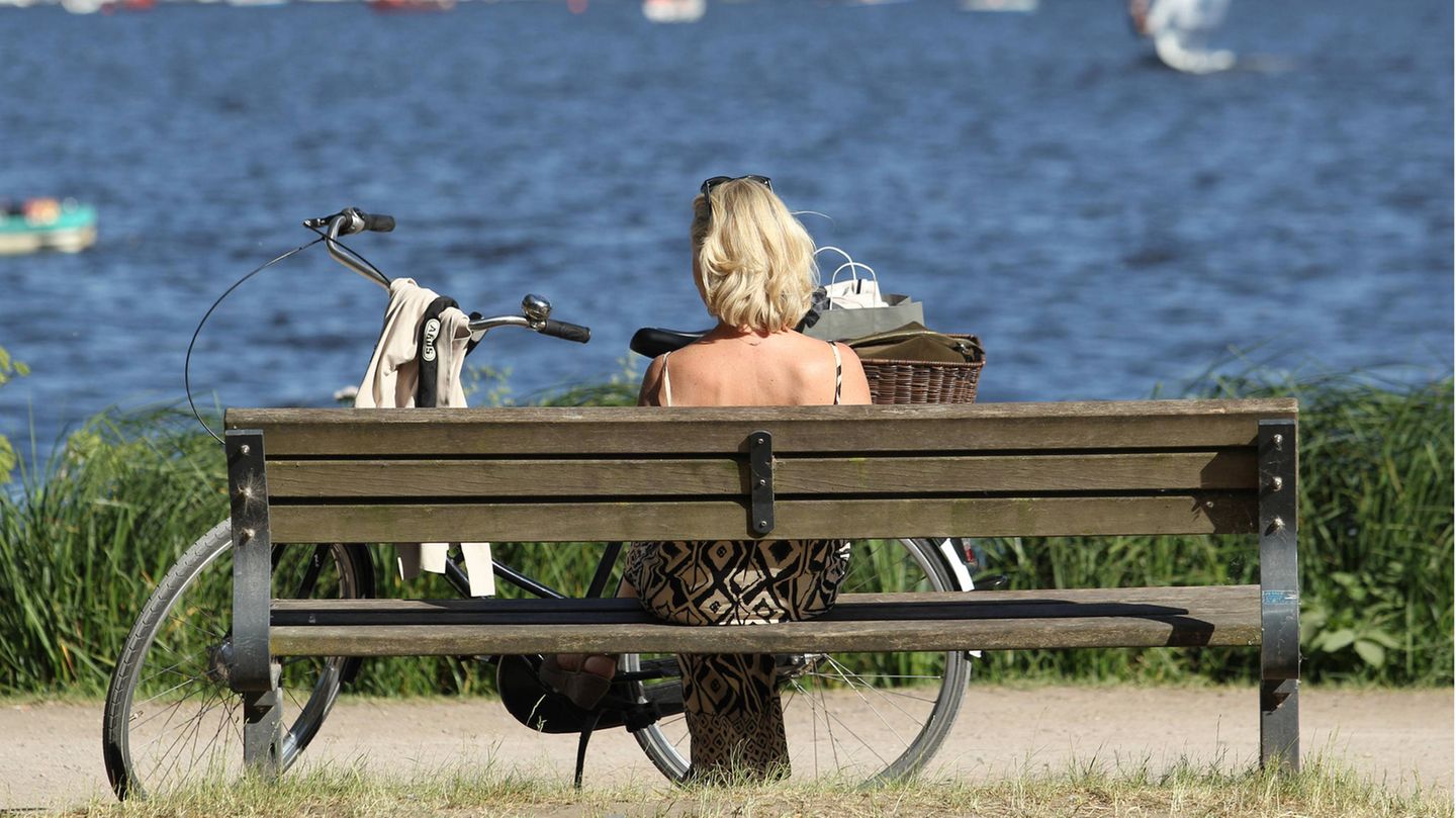 Eine Frau sitzt alleine auf einer Bank