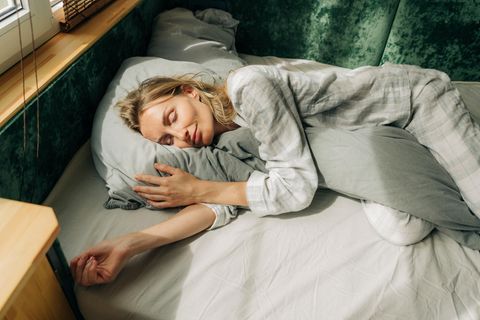 Frau schläft bei Hitze ohne Bettdecke