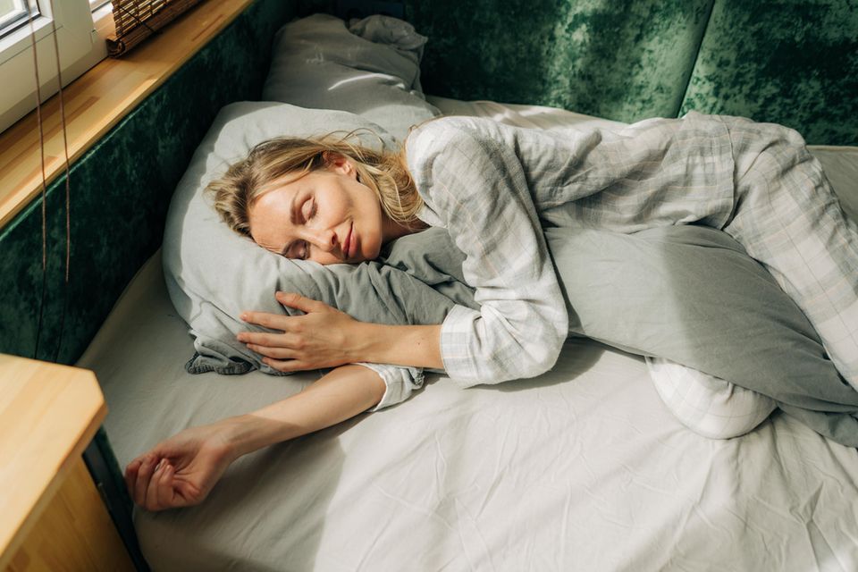 Frau schläft bei Hitze ohne Bettdecke