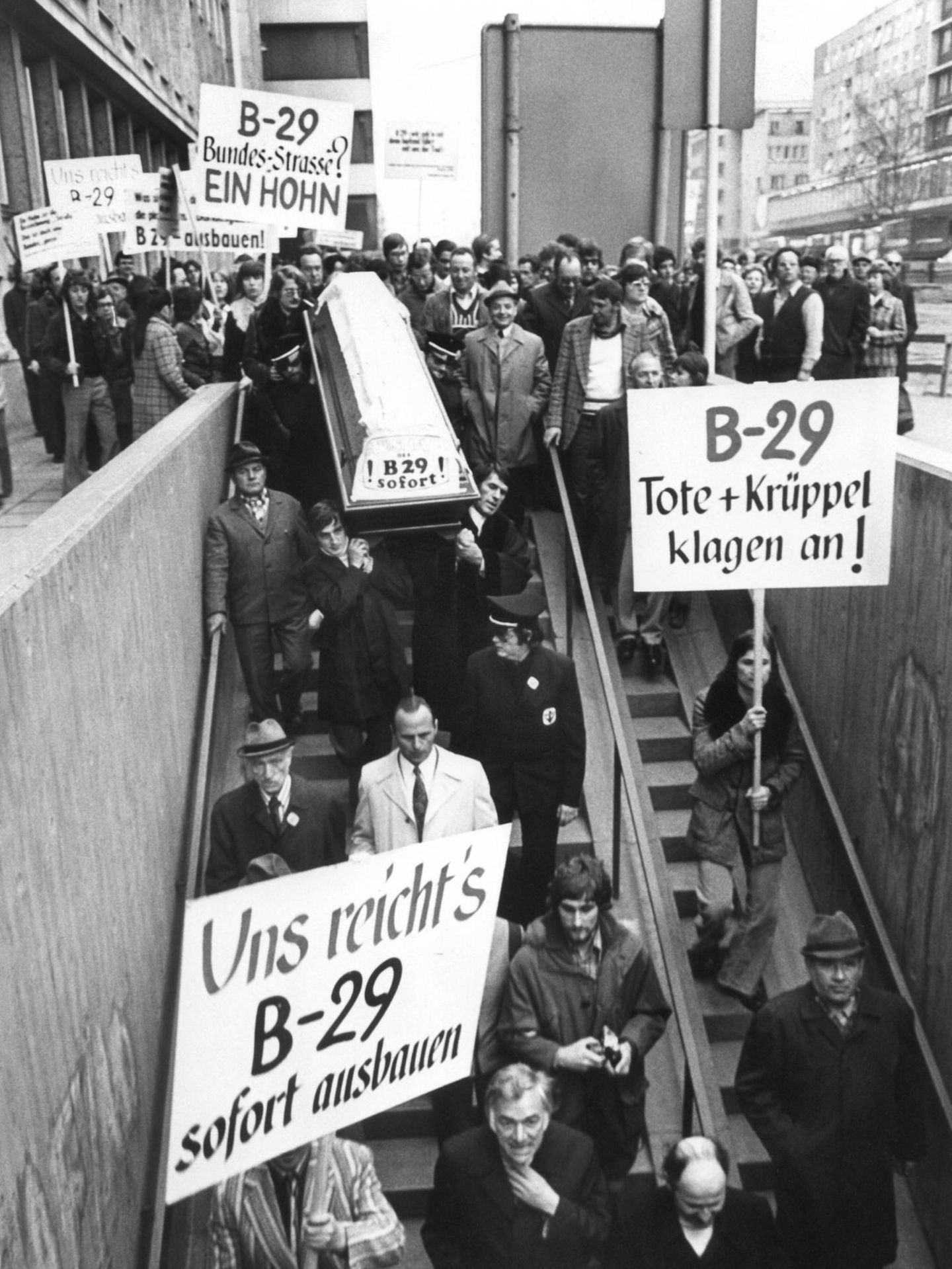 Menschen protestieren und halten Schilder in die Höhe. Aufschrift: Uns reicht! B29 sofort ausbauen