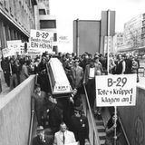 Menschen protestieren und halten Schilder in die Höhe. Aufschrift: Uns reicht! B29 sofort ausbauen