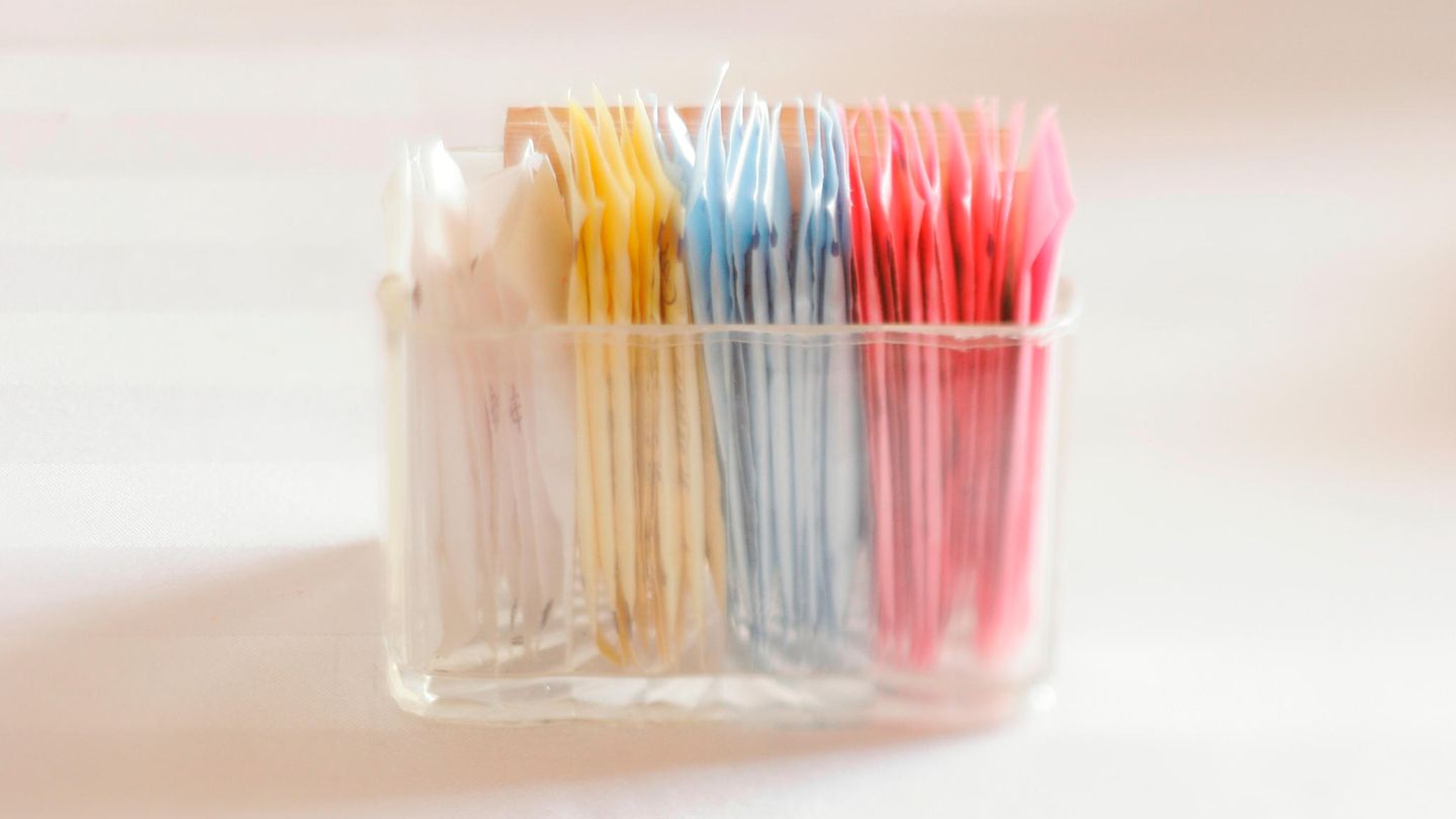Bunte Packungen mit Süßstoffen in einem durchsichtigen Schälchen
