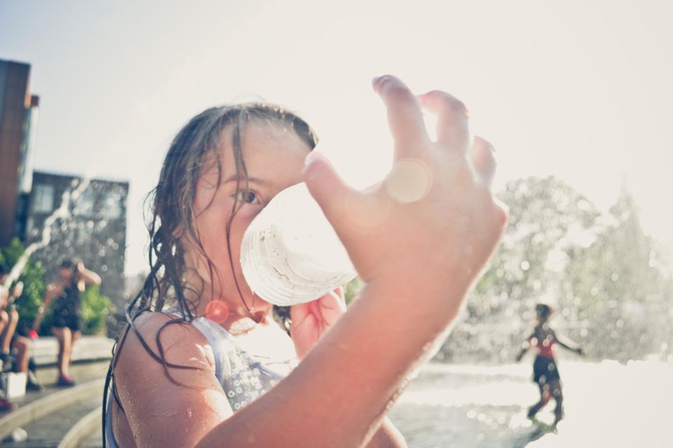 Junges Mädchen trinkt Wasser an einem heissen Tag in New York