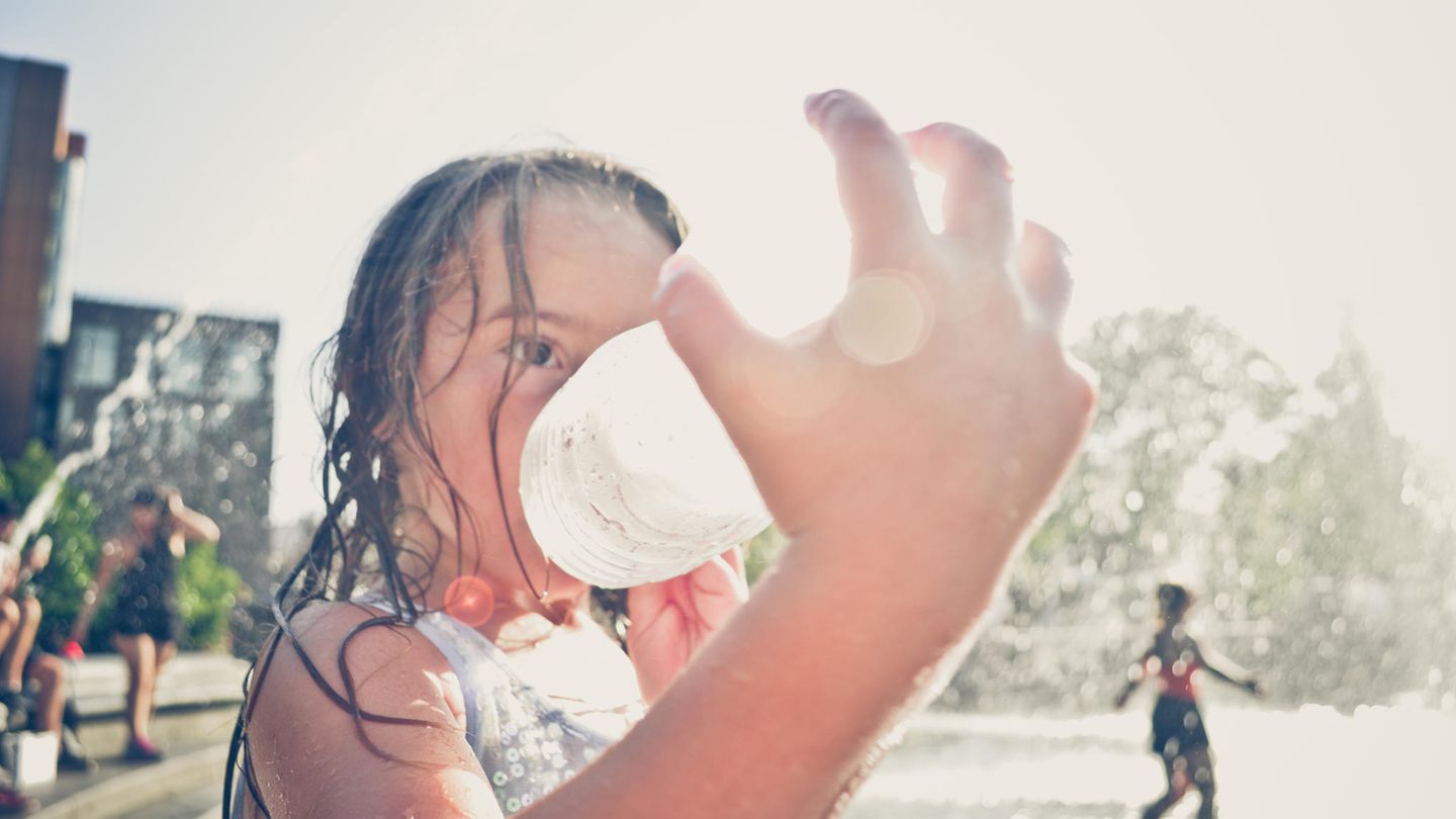 Junges Mädchen trinkt Wasser an einem heissen Tag in New York