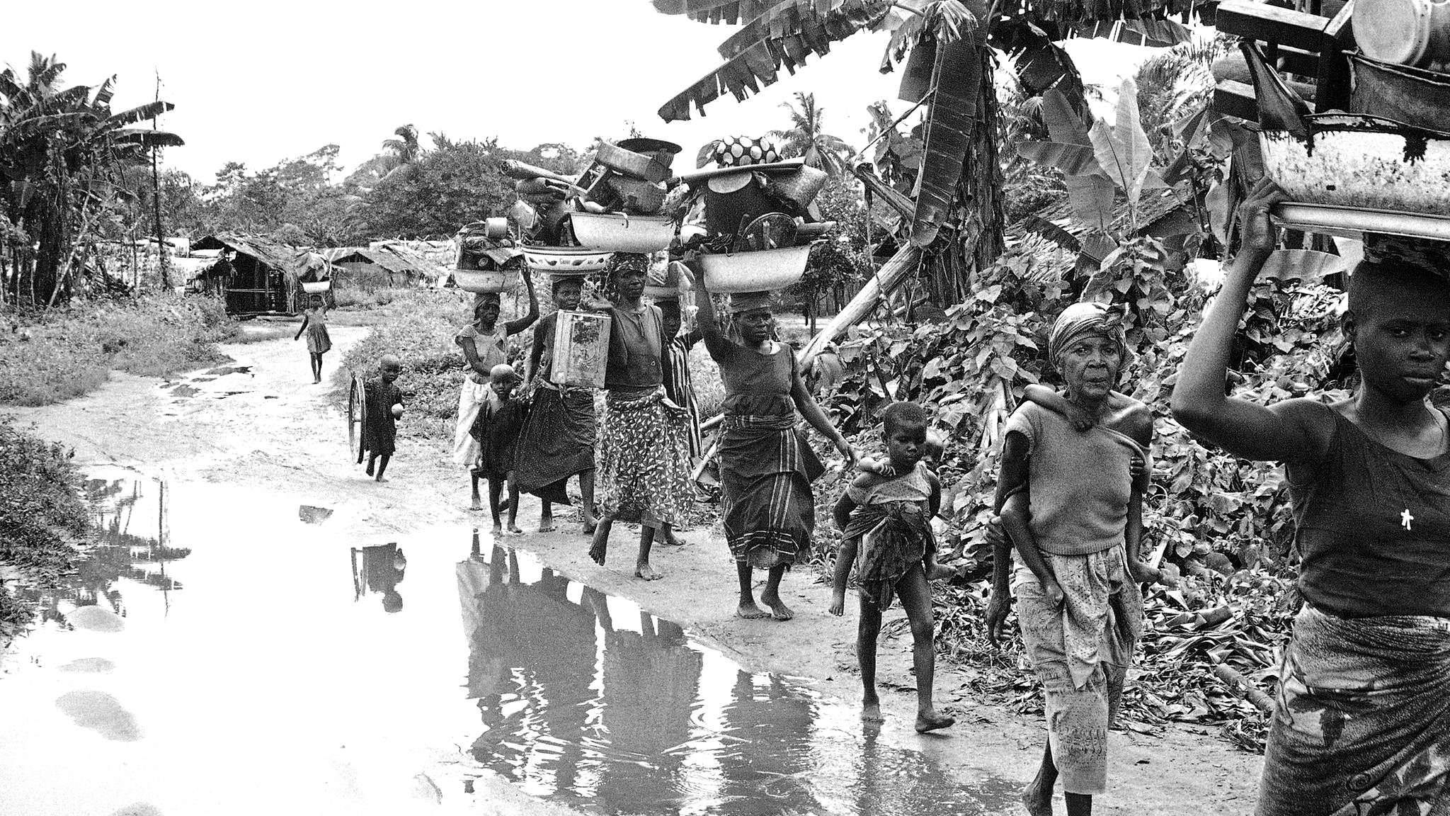 Keywords=XGV2011 Country/Primary Location Code=NGA Image Orientation=landscape Coded Character Set=UTF-8 By-line=Dennis Lee Royle Caption/Abstract=Ibo refugees from the breakaway Nigerian state of Biafra carry household goods on their heads as they flee advancing federal Nigerian troops near Owerri, Sept. 1968. Youngster at right carries another child. (AP Photo/Dennis Lee Royle)