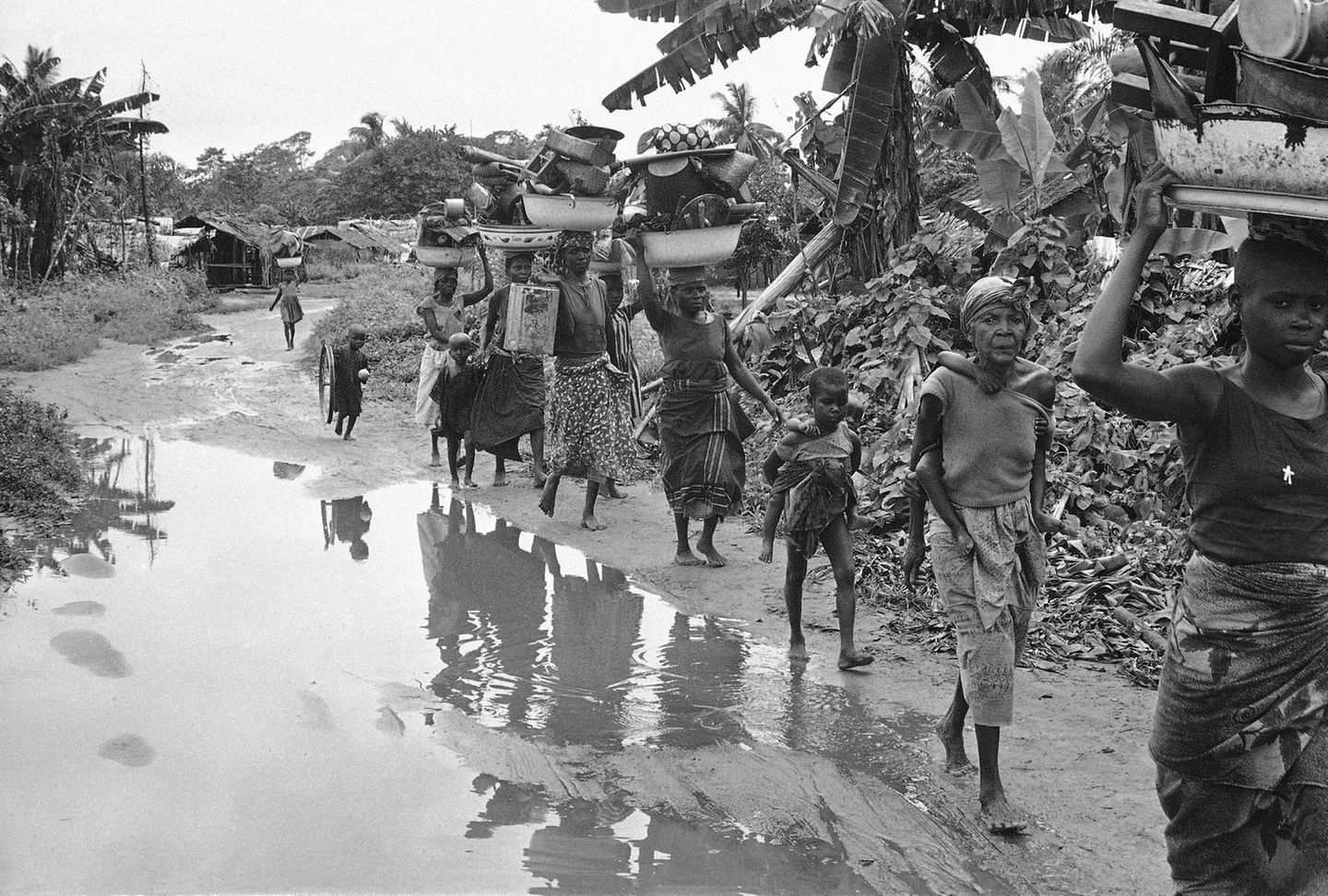 Keywords=XGV2011 Country/Primary Location Code=NGA Image Orientation=landscape Coded Character Set=UTF-8 By-line=Dennis Lee Royle Caption/Abstract=Ibo refugees from the breakaway Nigerian state of Biafra carry household goods on their heads as they flee advancing federal Nigerian troops near Owerri, Sept. 1968. Youngster at right carries another child. (AP Photo/Dennis Lee Royle)