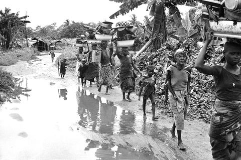 Keywords=XGV2011 Country/Primary Location Code=NGA Image Orientation=landscape Coded Character Set=UTF-8 By-line=Dennis Lee Royle Caption/Abstract=Ibo refugees from the breakaway Nigerian state of Biafra carry household goods on their heads as they flee advancing federal Nigerian troops near Owerri, Sept. 1968. Youngster at right carries another child. (AP Photo/Dennis Lee Royle)