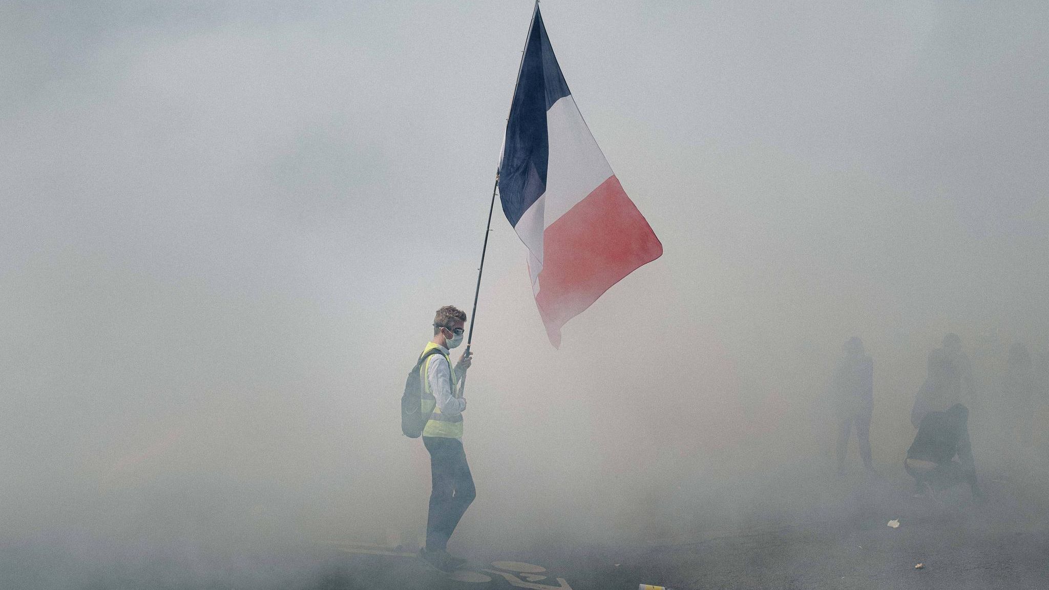 Nationalfeiertag in Paris: Gelbwesten-Demonstration 2020: Durch dichten Rauch leuchtet die Tricolore, Symbol der französischen Republik – aber auch Sinnbild der Revolution und des Widerstands gegen die Staatsgewalt