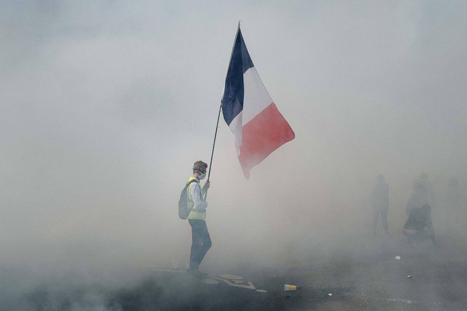 Nationalfeiertag in Paris: Gelbwesten-Demonstration 2020: Durch dichten Rauch leuchtet die Tricolore, Symbol der französischen Republik – aber auch Sinnbild der Revolution und des Widerstands gegen die Staatsgewalt