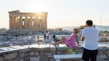 Amerikanische Touristin laesst sich vor der Akropolis in Athen fotografieren