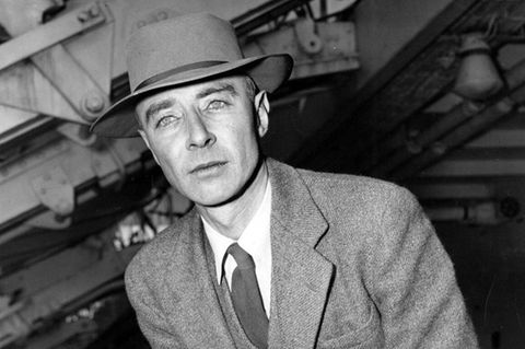 Robert Oppenheimer lehnt sich an einen Stuhl und hat eine Zigarette in der Hand