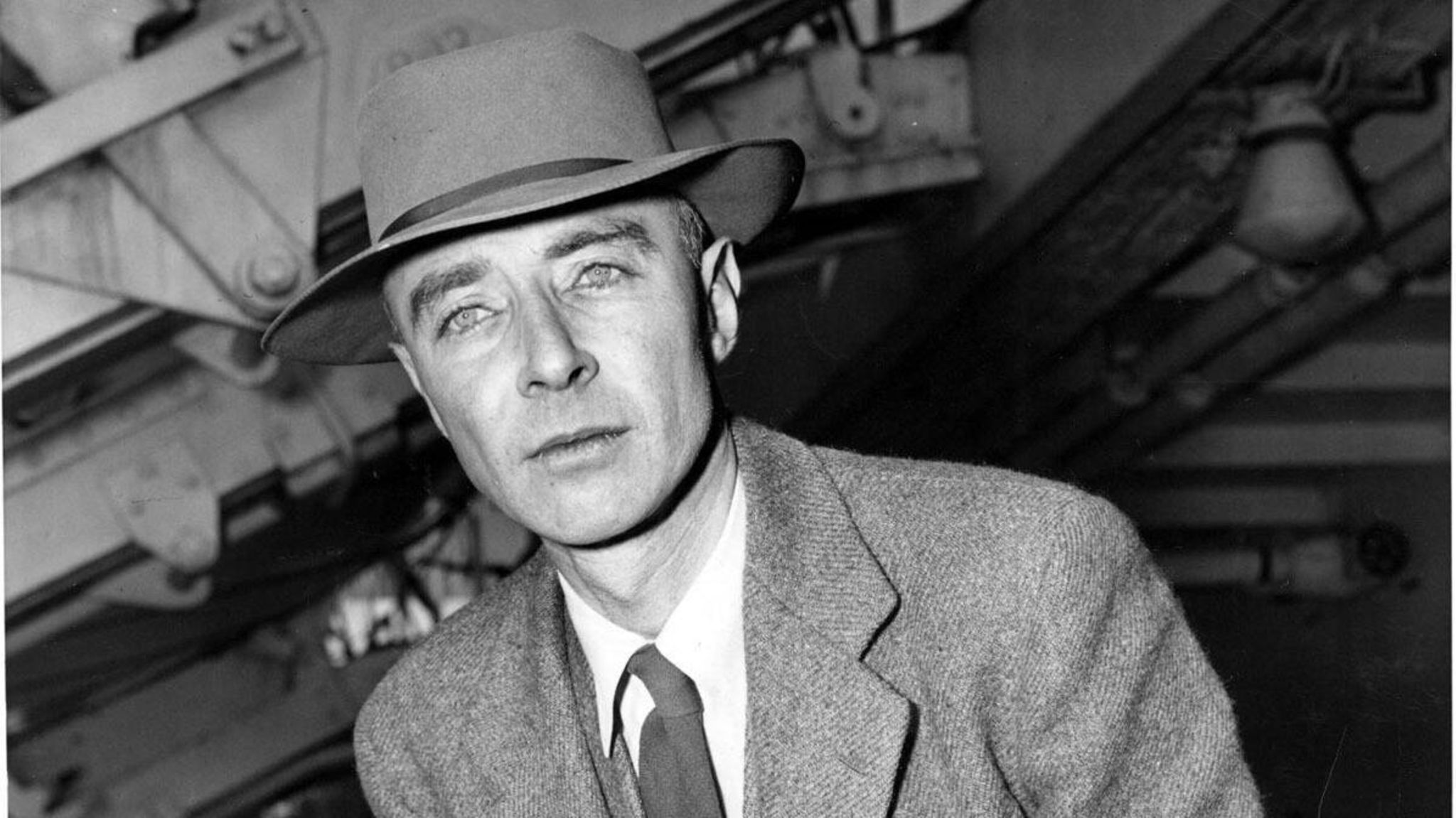 Robert Oppenheimer lehnt sich an einen Stuhl und hat eine Zigarette in der Hand