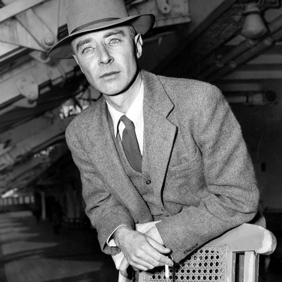 Robert Oppenheimer lehnt sich an einen Stuhl und hat eine Zigarette in der Hand
