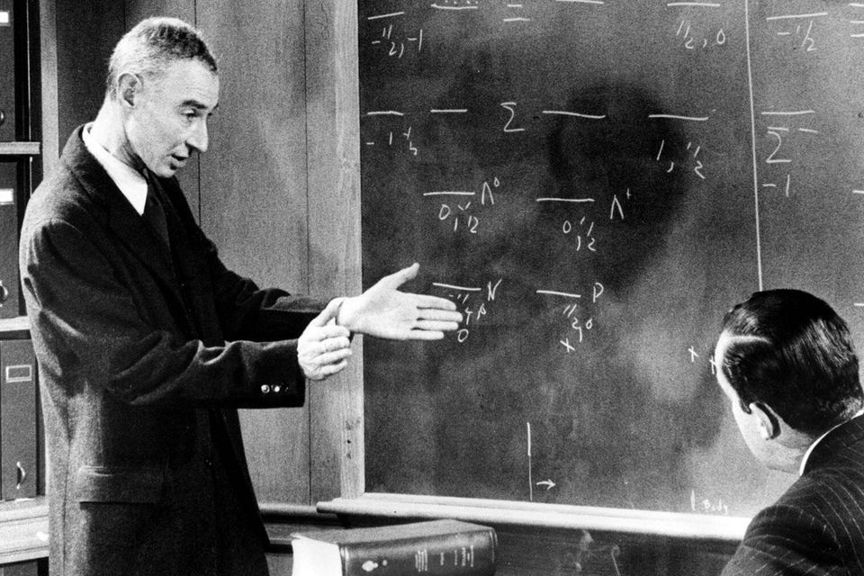 Robert Oppenheimer erklärt an einer Tafel Gleichungen