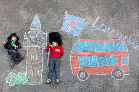 Zwei Kinder liegen in einem Kreidebild mit Doppeldeckerbus und Big Ben