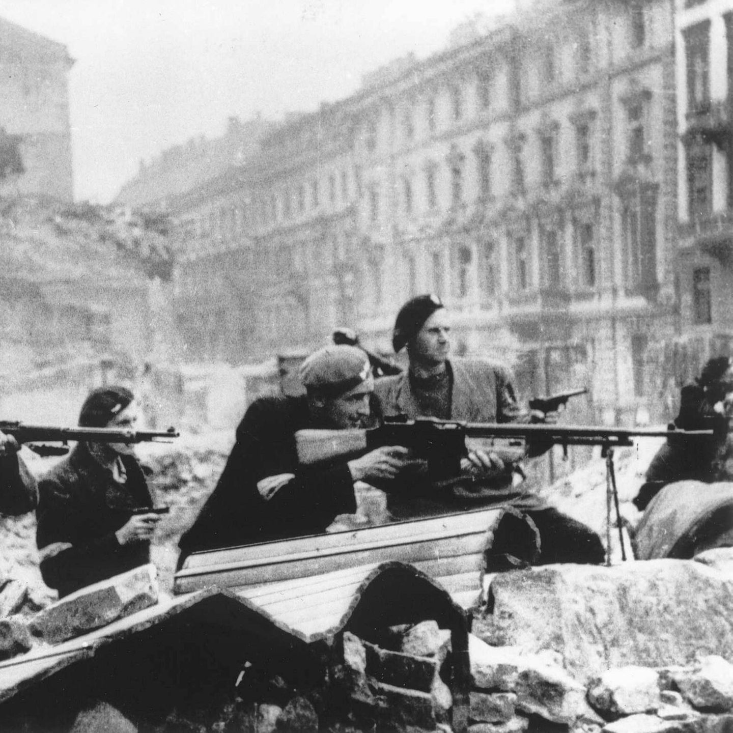 Polnische Soldaten in Warschau 1944 liegen mit ihren Gewehren im Anschlag hinter Trümmern