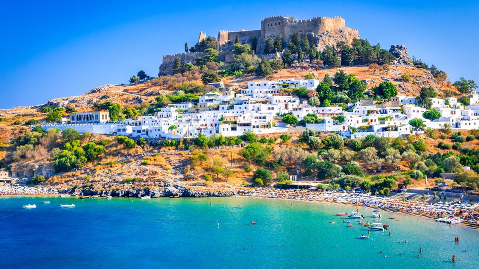 Der wunderschöne Sandstrand von Lindos erstreckt sich am Fuße des bildhübschen Dörfchens