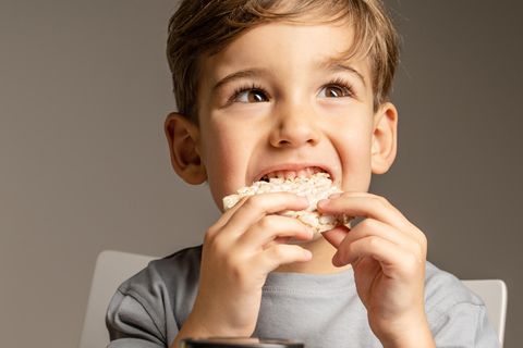 Ein Junge isst eine Reiswaffel