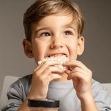 Ein Junge isst eine Reiswaffel