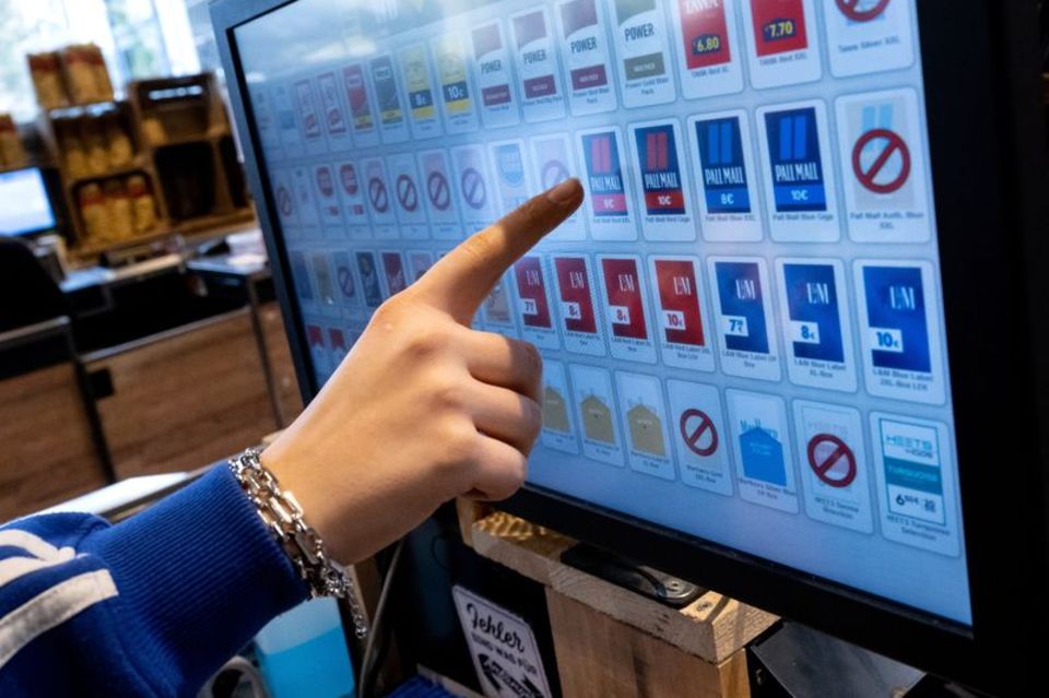 Mensch drückt auf Touch-Bildschirm und wählt eine Zigarettenmarke aus