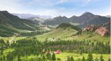 Weite, bergige Landschaft mit vereinzelten Häusern