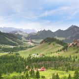 Weite, bergige Landschaft mit vereinzelten Häusern