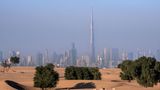 Dubai und Wildnis Skyline von Dubai mit einer Wüstenlandschaft im Vordergrund