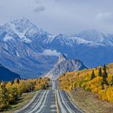 Eine Straße umgeben von hohen Bergen und Bäumen