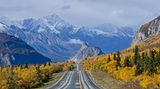 Roadtrip in Alaska – Unterwegs auf dem Glenn Highway Eine Straße umgeben von hohen Bergen und Bäumen