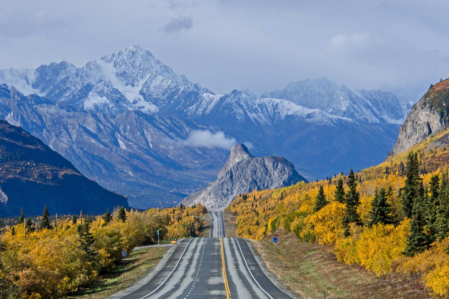 Roadtrip in Alaska – Unterwegs auf dem Glenn Highway Eine Straße umgeben von hohen Bergen und Bäumen