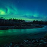 Grüne Polarlichter an einem Fluss
