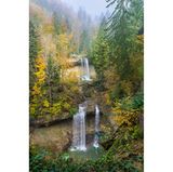 Blick auf einen Wasserfall mit herbstlich-verfärbten Bäumen rundherum