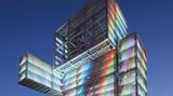 Der Aussichtsturm sieht aus wie ein klobiger, dicker Mann, er leuchtet zum Sonnenuntergang in Regenbogenfarben.
