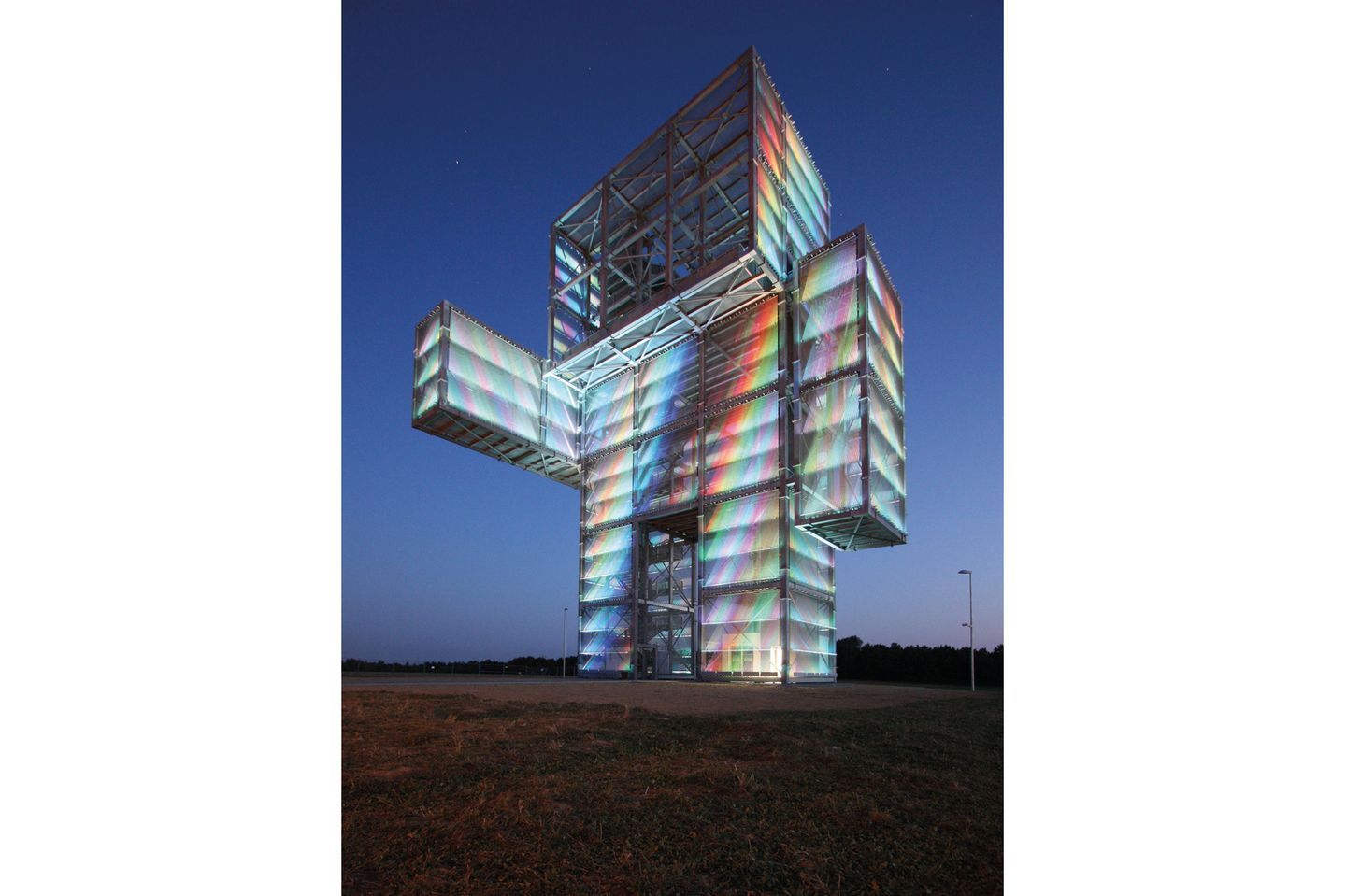 Bald am Ozean: Indemann, Nordrhein-Westfalen Der Aussichtsturm sieht aus wie ein klobiger, dicker Mann, er leuchtet zum Sonnenuntergang in Regenbogenfarben.