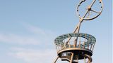 Der Turm ist schräg, ganz oben ist eine Uhr, neben der Treppe führt eine spindelförmige Rutsche nach unten.