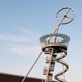 Der Turm ist schräg, ganz oben ist eine Uhr, neben der Treppe führt eine spindelförmige Rutsche nach unten.