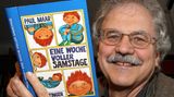 Kinderbuchautor Paul Maar zeigt eines seiner Bücher
