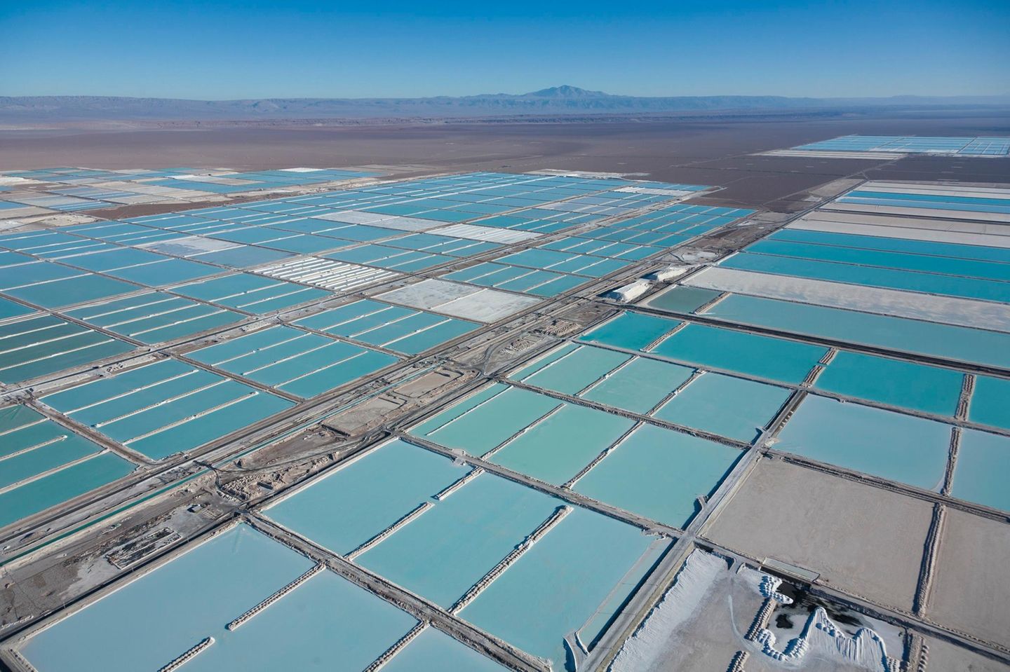 Im Salar de Atacama, der über 3000 Quadratkilometer großen Salzwüste im Osten Chiles, wird ein Rohstoff gewonnen, den die Welt braucht: für Smartphones und Laptops, E-Autos und Stromspeicher. Bergbauunternehmen pumpen lithiumchloridhaltige Sole aus unterirdischen Reservoirs an die Erdoberfläche, leiten sie in fußballfeldgroße Becken und setzen sie dort der Sonne aus. Das Wasser verdunstet und nach mehreren Monaten enthält die Sole etwa sechs Prozent Lithium. Mit einer chemischen Anlage gewinnen Arbeiter Lithiumcarbonat aus dem Gemisch: ein weißes Pulver, das zu Lithiumhydroxid weiterverarbeitet und für die Herstellung von Lithium-Ionen-Akkus exportiert wird.