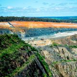 Der Cornwall Pit, ein gigantischer Tagebau im Südwesten Australiens, frisst sich seit den 1880er-Jahren durch die Landschaft. Dass die Gesteinsschichten auch Lithiumablagerungen beinhalten, wissen die Bergbauunternehmen seit über 50 Jahren. Lange förderten sie das Alkalimetall jedoch nur in kleinen Mengen: für die Keramikproduktion etwa. Seit jedoch die Weltmarktpreise für Lithium in die Höhe schießen, boomt auch das Geschäft der Minenbetreiber. Sie sprengen große Pegamititblöcke aus den Abbruchkanten: ein grobkörniges, granitähnliches Gestein, das mancherorts sechs Prozent Lithium beinhaltet. Nachdem die Gesteinsbrocken gebrochen und gemahlen wurden, werden sie chemisch aufbereitet. Auch am Ende dieser Produktionskette entsteht meist Lihtiumcarbonat, das zu großen Teilen nach China exportiert wird, wo es zu Lithiumhydroxid weiterverarbeitet und in Lithium-Ionen-Akkus verbaut wird. Der australische Tagebau steht wegen seiner Flächenverbrauchs, vor allem aber wegen seiner Treibhausgasemissionen in der Kritik: Laut dem Marktanalysten Roskill emittiert die Produktion einer australischen Tonne Lithium etwa 9 Tonnen Kohlendioxid.
