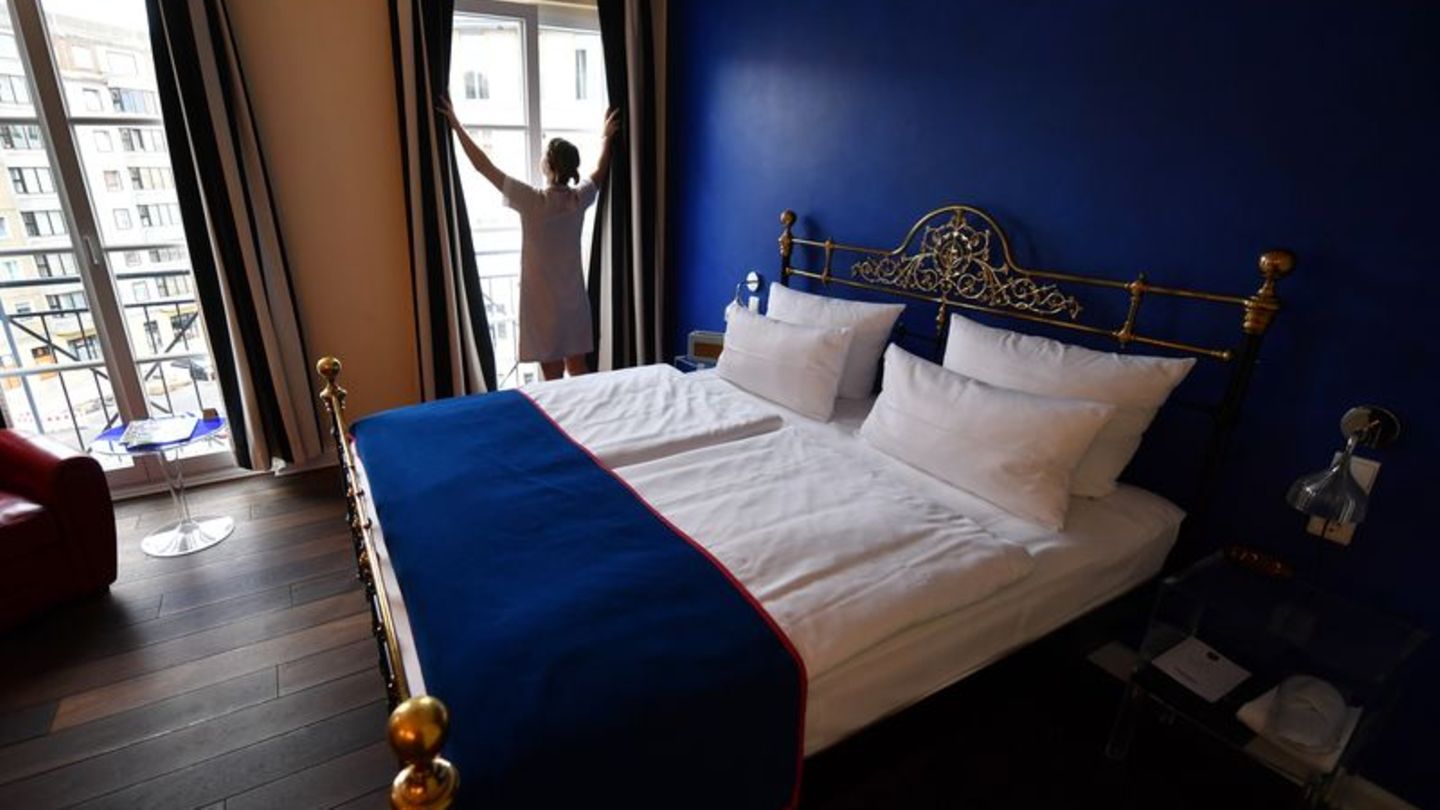 Eine Frau steht am Fenster eines Zimmers im Boutique-Hotel "The Dude" in Berlin