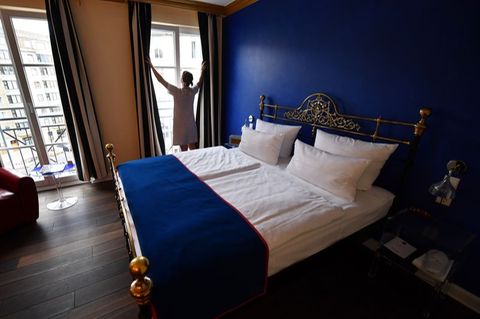 Eine Frau steht am Fenster eines Zimmers im Boutique-Hotel "The Dude" in Berlin
