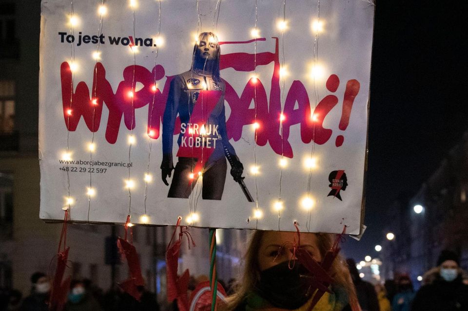 Protestierende halten in Warschau Schilder in die Luft mit Parolen gegen die polnische Regierung