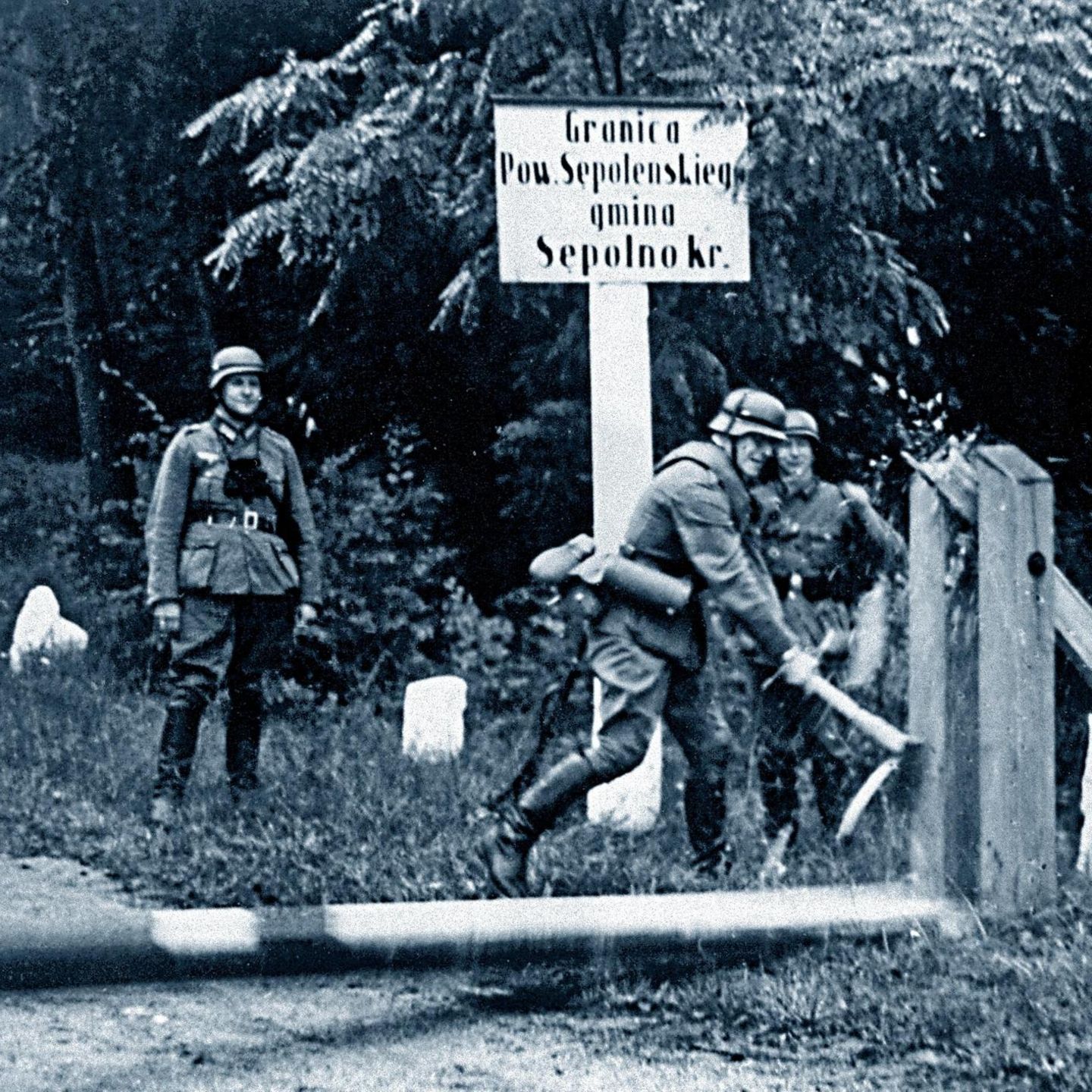Ein deutscher Soldat schlägt mit einer Axt auf einen Schlagbaum an der deutsch-polnischen Grenze ein